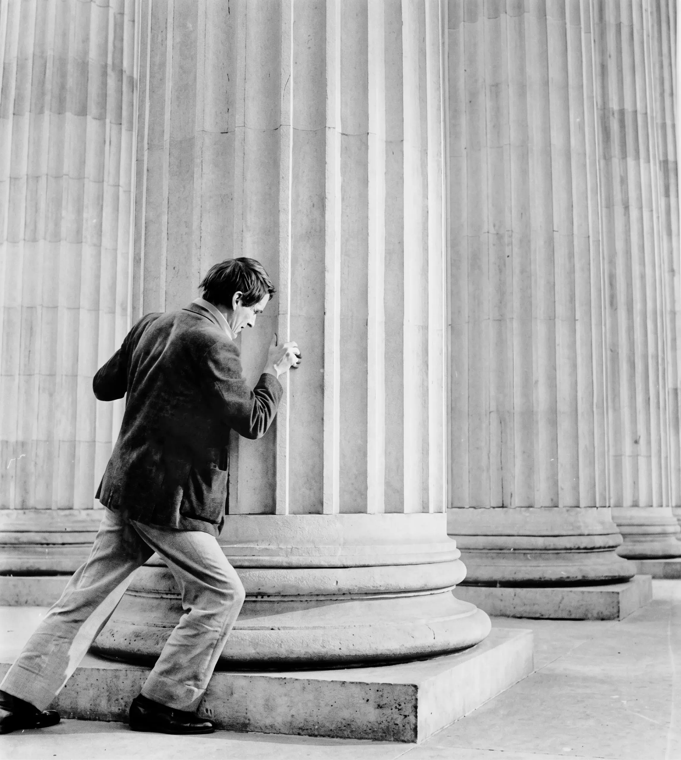 Gonzalo Arango hace el gesto de empujar una de las gigantescas columnas acanaladas del Congreso de la República.