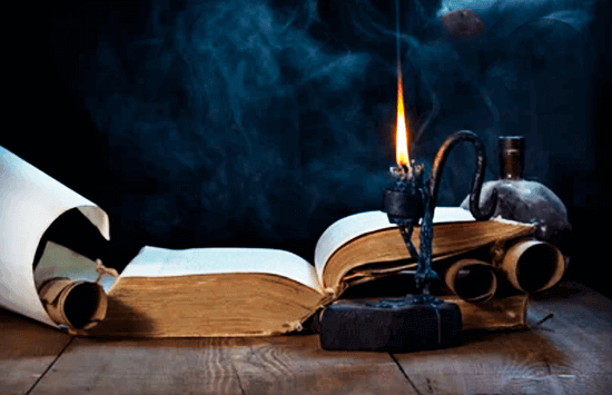 Libro antiguo iluminado por una vela