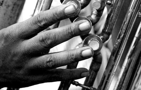 Primer plano de una mano tocando un instrumento musical. Foto de Steve Cagan.